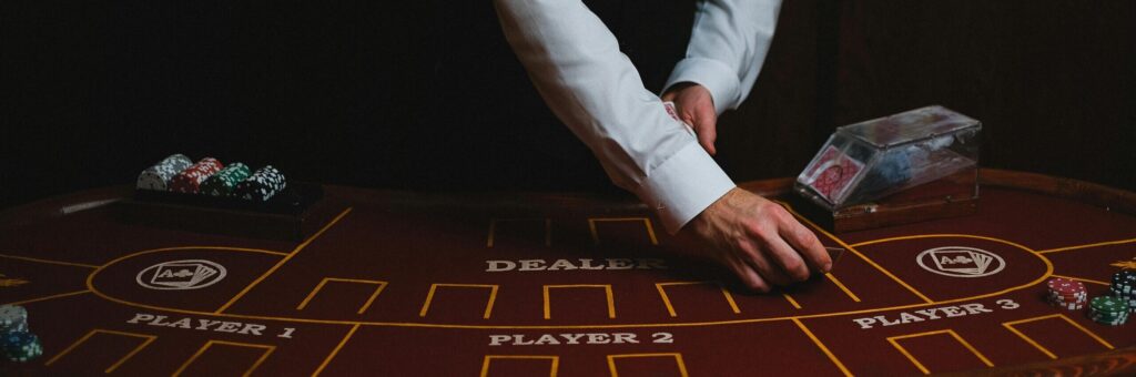 Fotografie eines Mannes im Anschnitt der Karten auf einem Pokertisch aufdeckt.