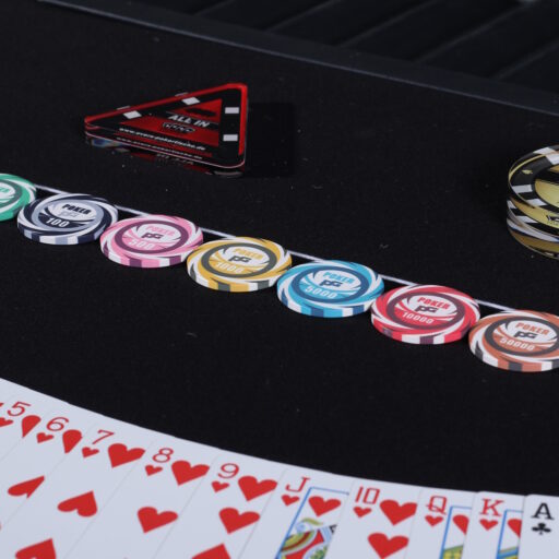 Eine saubere Anreihung von Poker Chips mit ein paar Karten im Hintergrund in einem Fächer