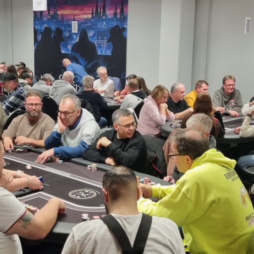 Eine vielzahl an Personen sitzt an Pokertischen und Spielt Poker